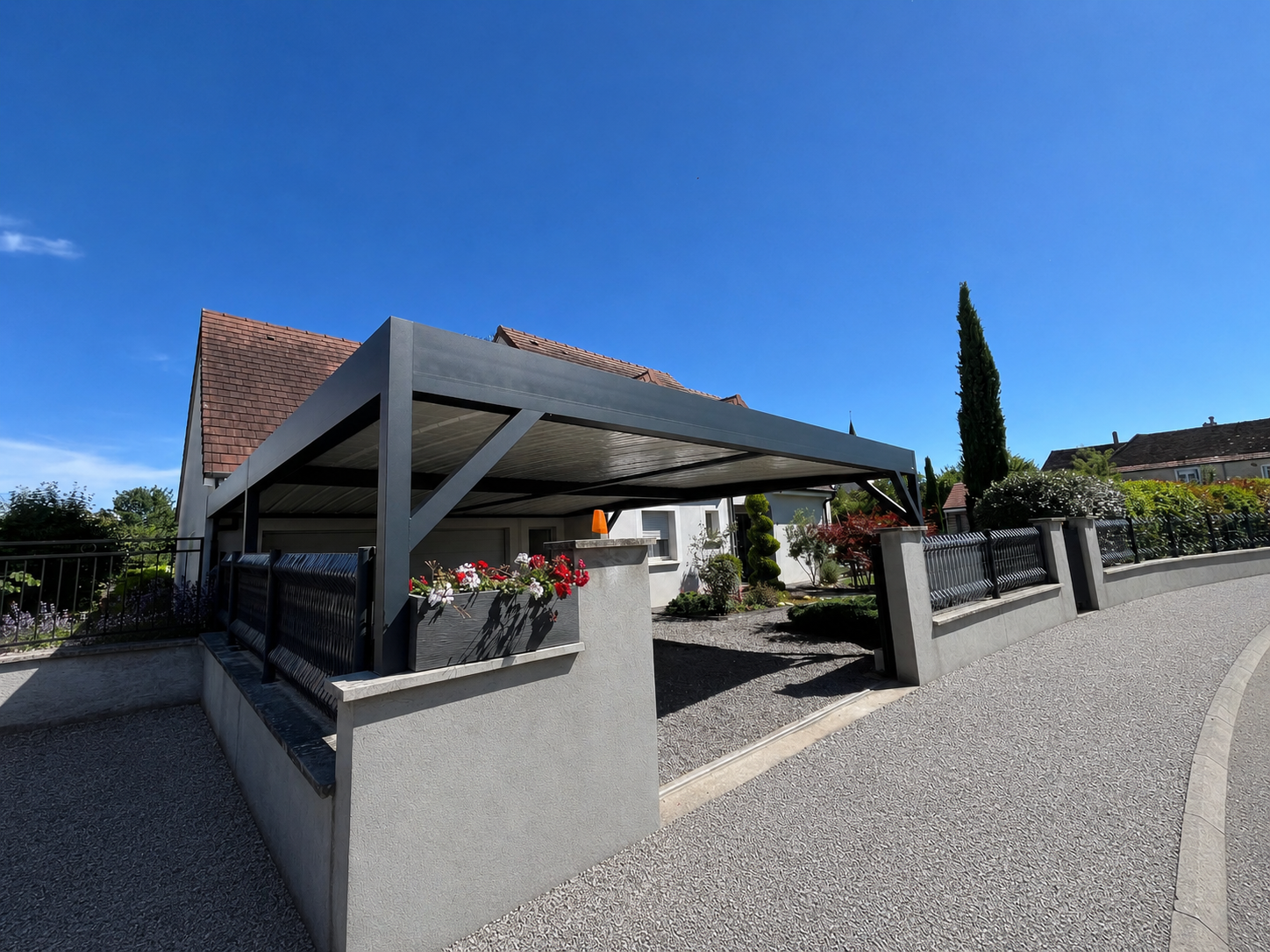 Carport en aluminium fixé sur murets à l'intérieur d'une cour