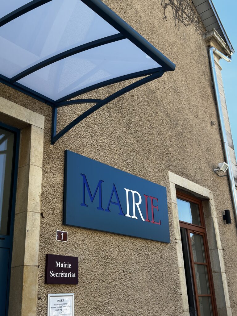 Enseigne de mairie en aluminium bleu, blanc et rouge installée sous une marquise en aluminium thermolaqué bleu.