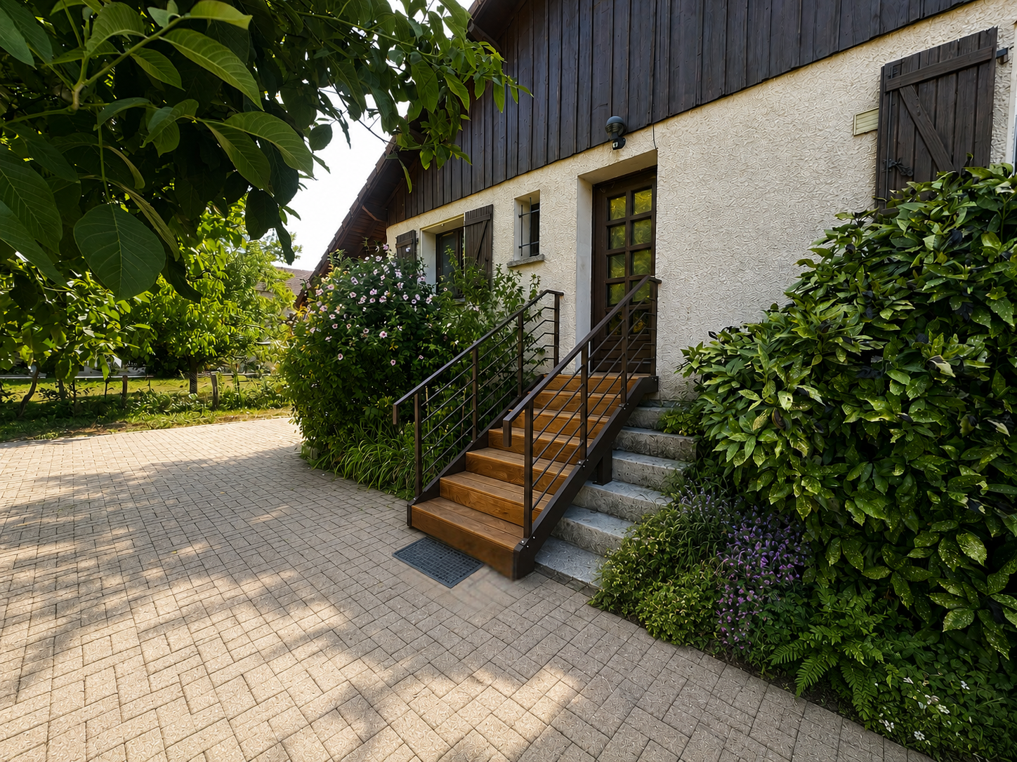 Escalier extérieur en aluminium brun RAL 8028 avec marches en bois Cumaru devant une maison à Pessans