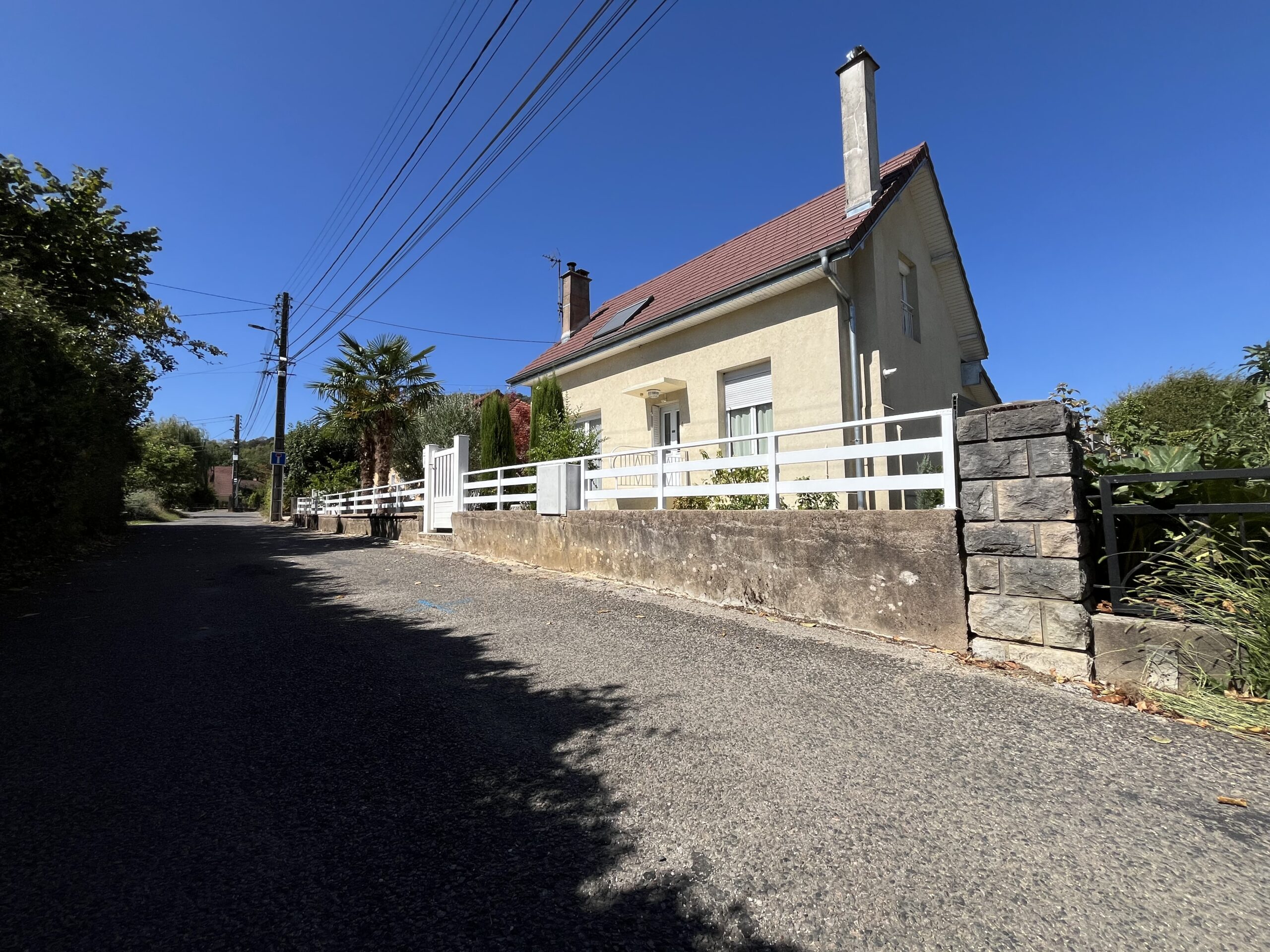 Barrière extérieure en aluminium blanc posée sur un muret devant une maison à Besançon.