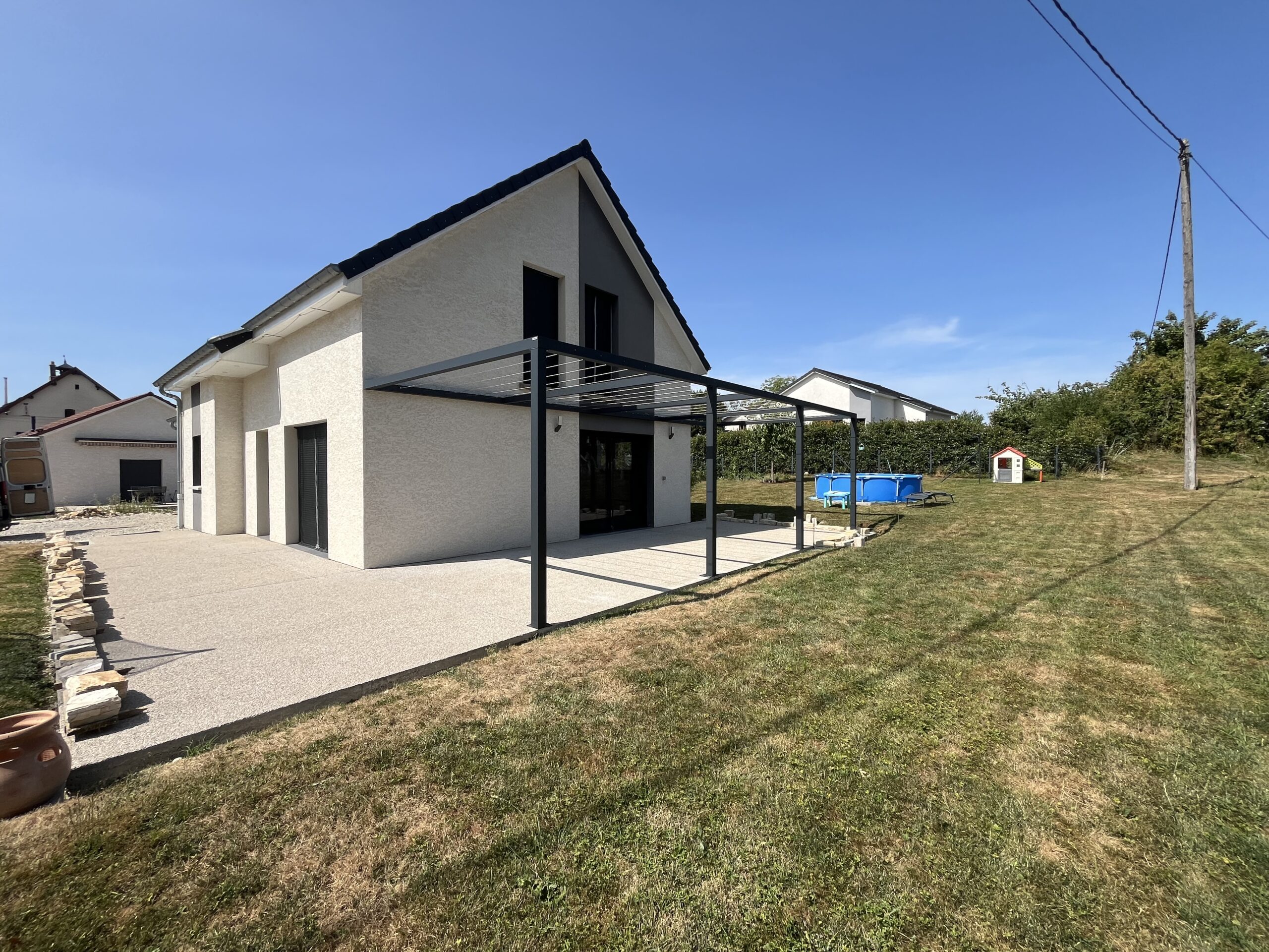 Structure aluminium sur mesure avec câbles inox installée autour d’une grande terrasse extérieure.